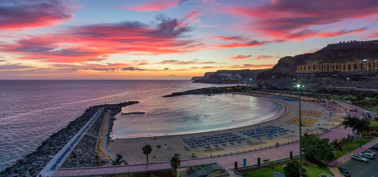 La bahía de Amadores al atardecer, con el espigón y el paseo encendido